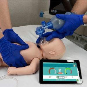 Infant BLS manikin showing real-time CPR performance reporting screen on tablet