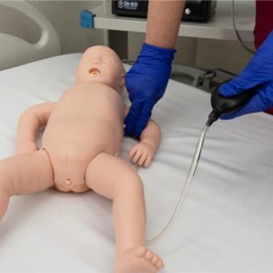 Infant BLS manikin showing real-time CPR performance reporting screen on tablet