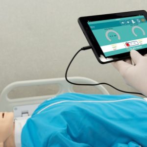 CPR manikin controller showing feedback lights for compression depth and ventilation