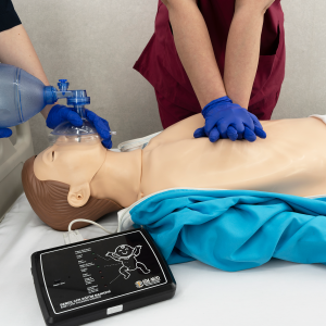 CPR manikin controller showing feedback lights for compression depth and ventilation