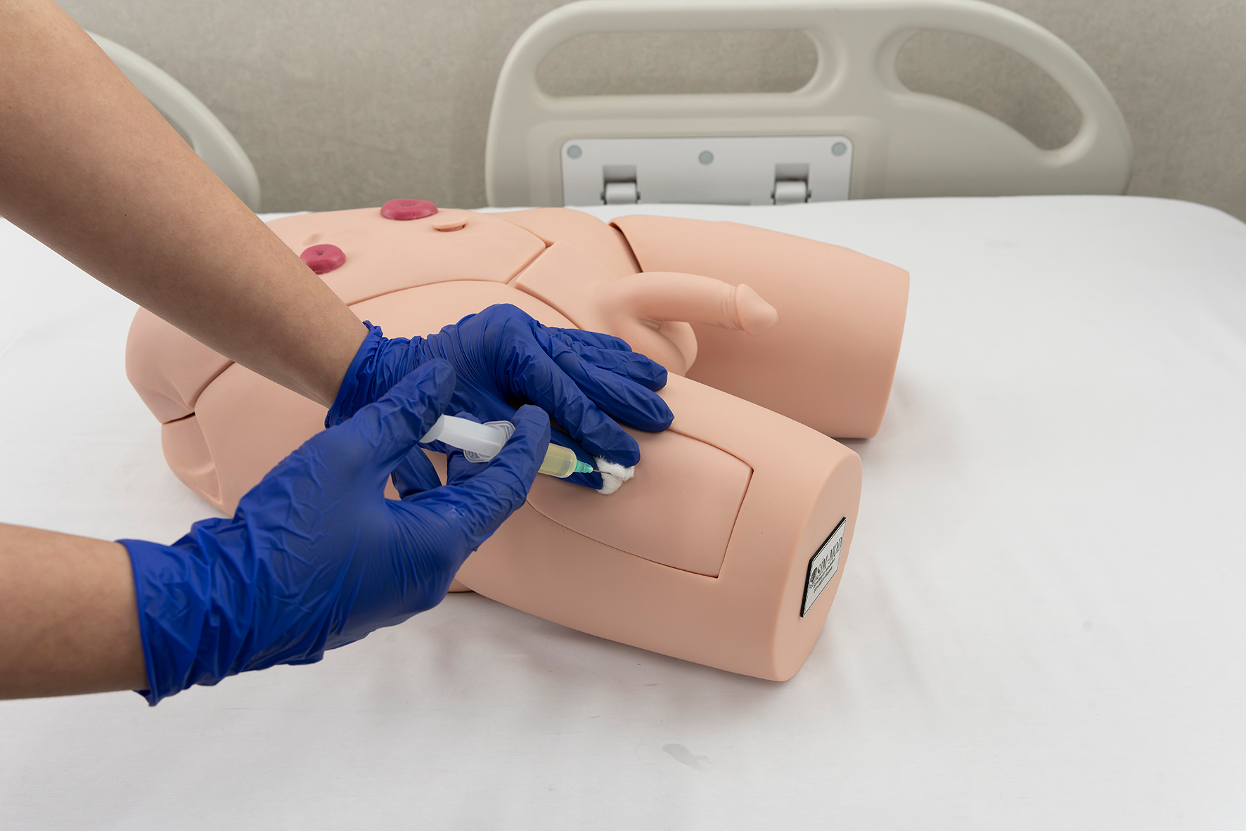 ns89a-2 Male catheterization trainer showing IM injection pads and fluid-based urethral insertion